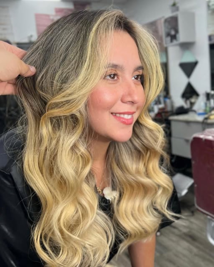 Client smiling with long blonde balayage waves