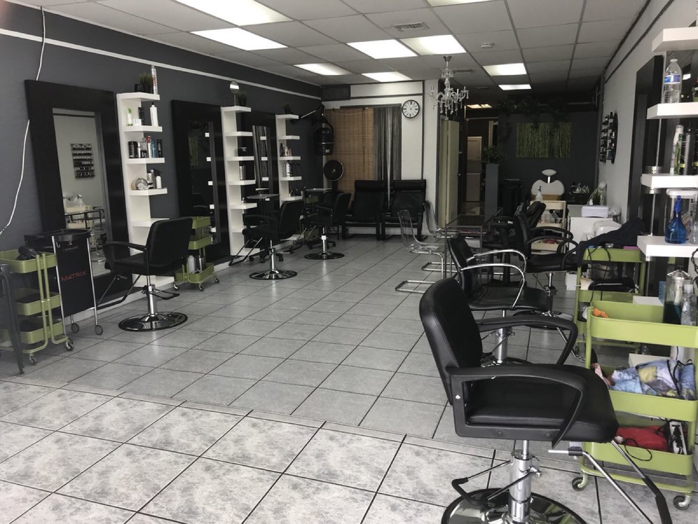 Black styling chairs and mirror stations along the salon wall