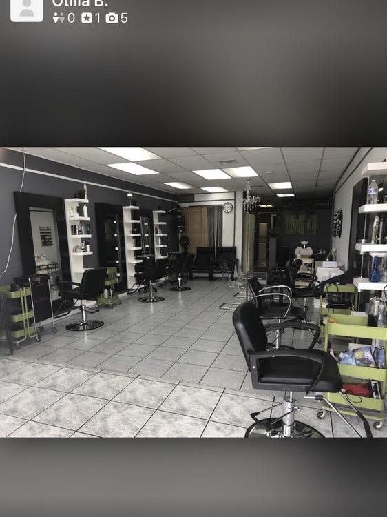 The salon floor with black chairs, grey mirror stations and white tile